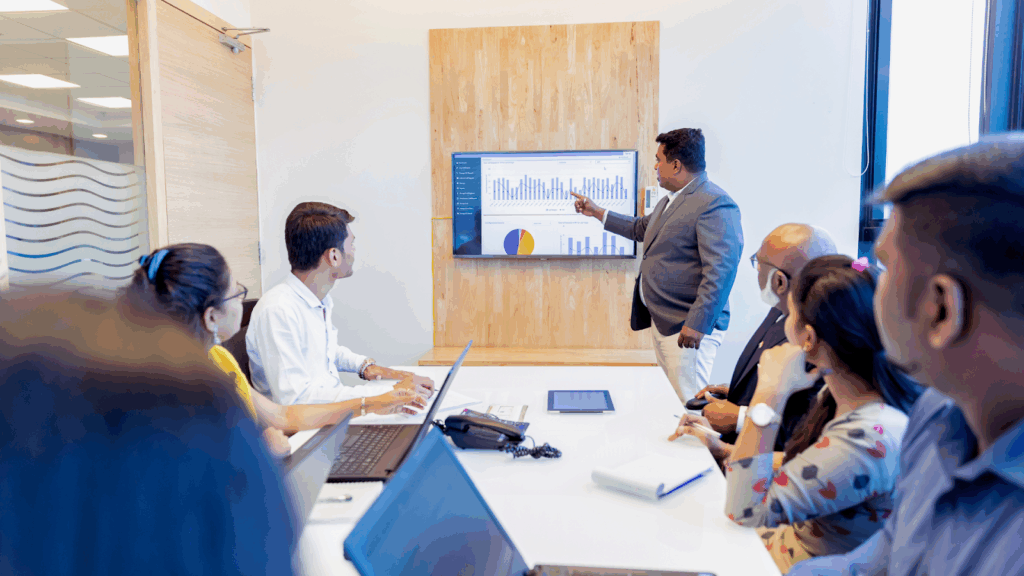 Business professional presenting financial charts to a team during a meeting