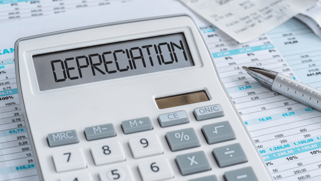 Calculator showing DEPRECIATION with finance papers and a pen