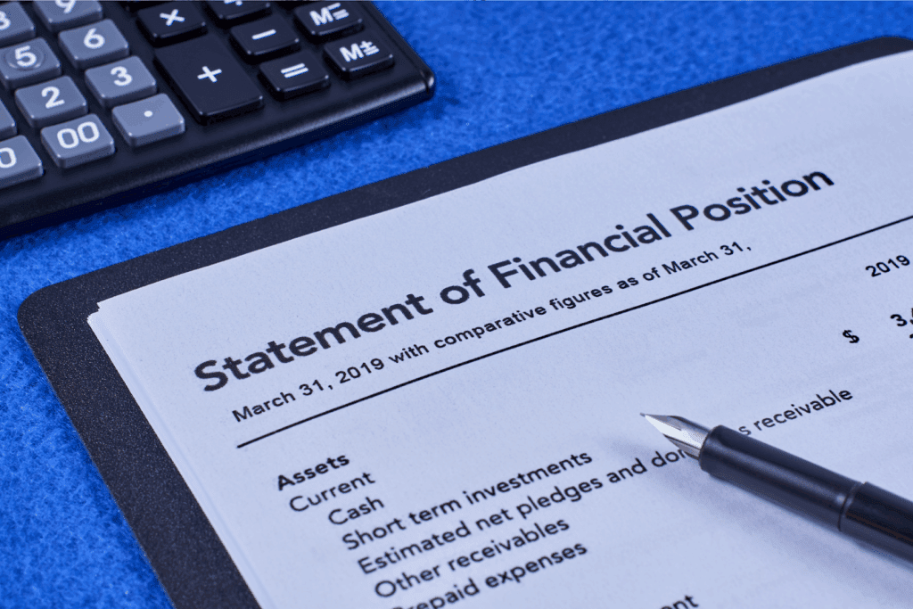 Close-up of a "Statement of Financial Position" document with a pen and calculator on a desk.