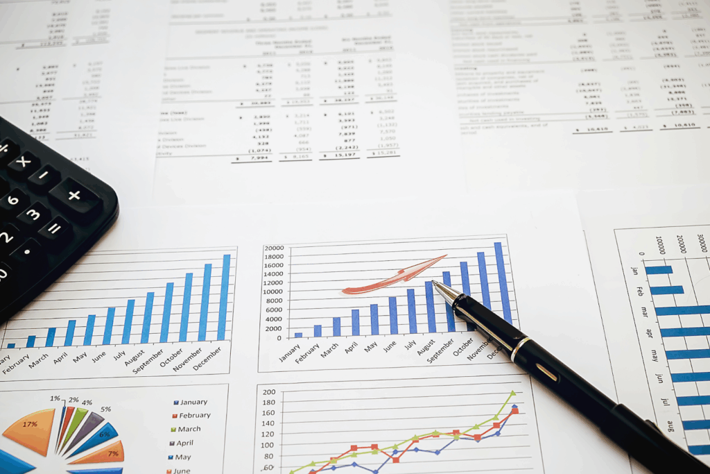 Financial charts and graphs with a calculator and pen on a desk