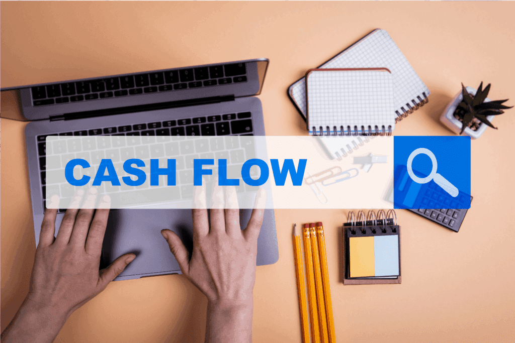 Hands typing on a laptop with Cash Flow text overlay