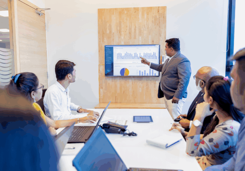 Business professional presenting financial charts to a team during a meeting