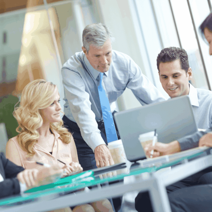 Business team gathered around a laptop in a modern office meeting