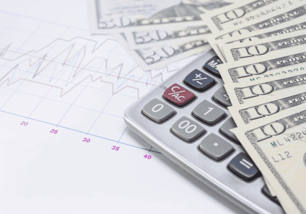 Calculator and US dollar bills on top of financial graph