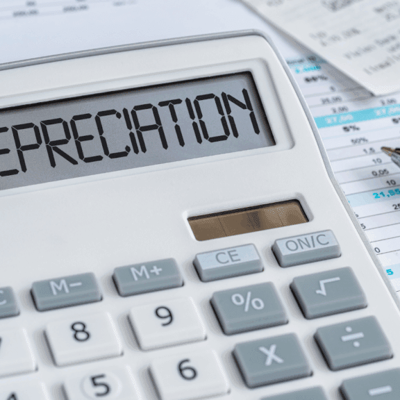 Calculator showing DEPRECIATION with finance papers and a pen