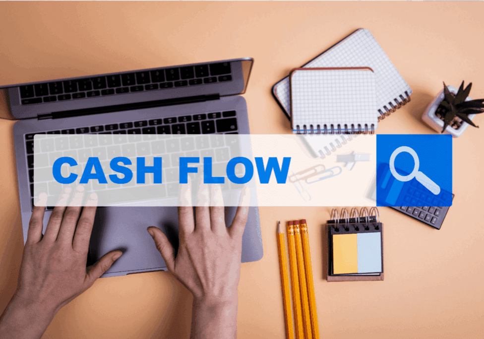 Hands typing on a laptop with Cash Flow text overlay