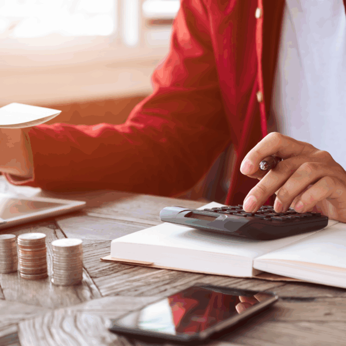 Person calculating finances with coins calculator and passbook on desk