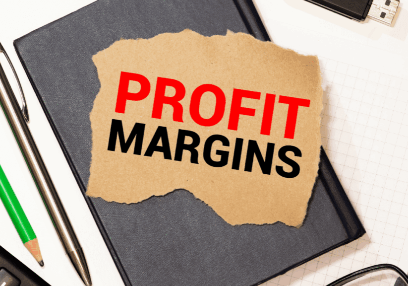 Torn paper with PROFIT MARGINS text on office desk