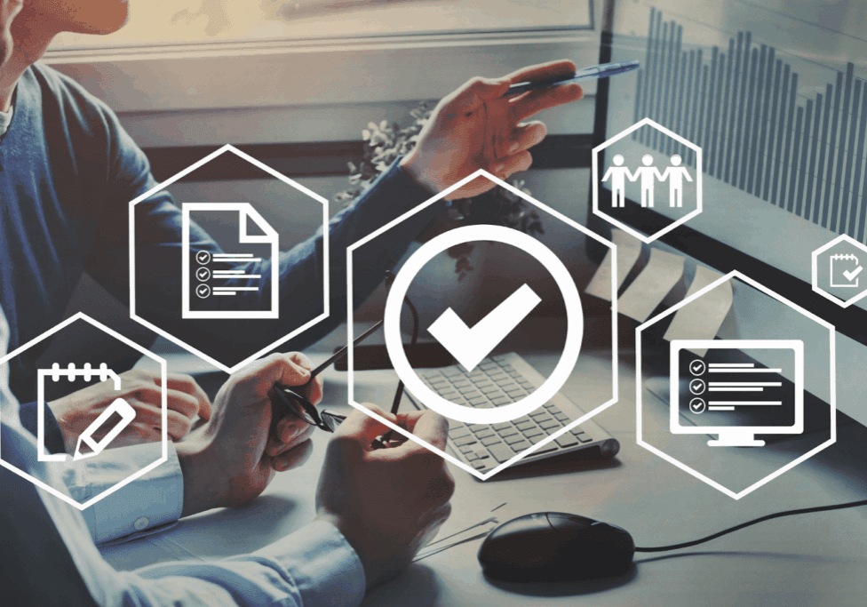 Hands pointing at charts on a screen with an overlay of digital compliance icons.