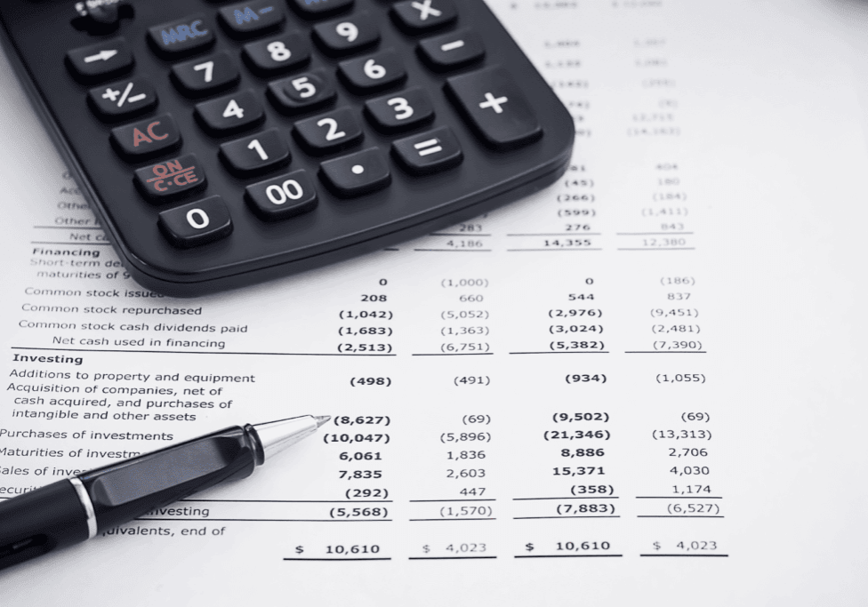 Calculator and pen on a financial statement or report.