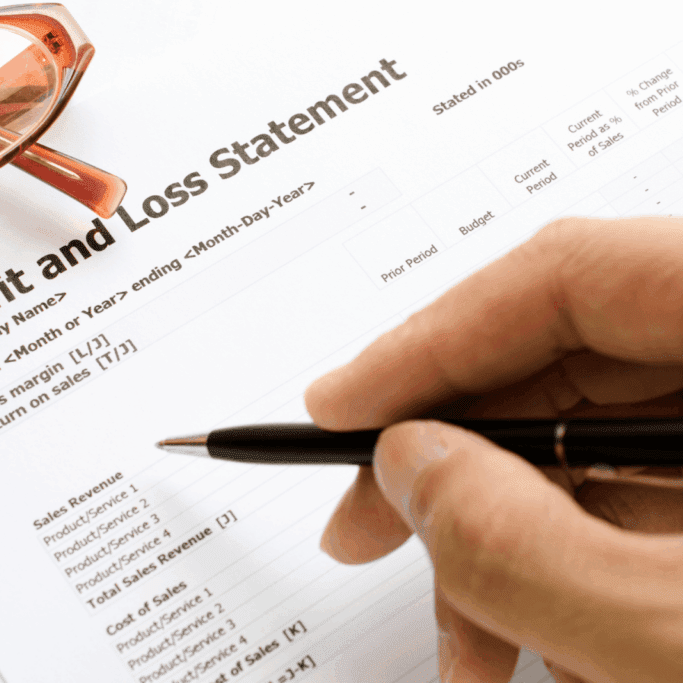 Balance sheet document with financial figures and a black-and-gold pen on top.